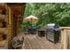 Inviting deck with a grill, dining table, and umbrella, ideal for outdoor gatherings and enjoying the natural surroundings at 6605 Old White Mill Rd, Fairburn, GA 30213