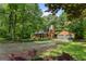 Exterior of a log cabin home surrounded by mature trees and lush greenery at 6605 Old White Mill Rd, Fairburn, GA 30213