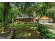 Charming log home with a covered front porch, lush landscaping, and a detached two-car garage at 6605 Old White Mill Rd, Fairburn, GA 30213