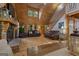 Open-concept living area with log walls, a stone fireplace, and comfortable seating, ideal for relaxing and entertaining guests at 6605 Old White Mill Rd, Fairburn, GA 30213