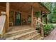Charming porch with rocking chairs and a welcoming green door, providing a cozy entrance to this log home at 6605 Old White Mill Rd, Fairburn, GA 30213