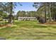 Expansive backyard featuring a home with large lawn, bordered by mature trees and a chain-link fence at 150 Whitney Way, Fayetteville, GA 30214