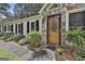 Home's entryway features a wood door with stone accents and manicured landscaping at 150 Whitney Way, Fayetteville, GA 30214