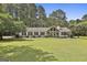 Charming ranch home features a spacious front yard, stone accents, and manicured landscaping at 150 Whitney Way, Fayetteville, GA 30214