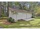 Detached three-car garage featuring a side door, manicured landscaping and concrete driveway at 150 Whitney Way, Fayetteville, GA 30214