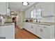 Bright kitchen features white cabinets, granite countertops, a gas range, and stainless steel appliances and a view into the living room at 150 Whitney Way, Fayetteville, GA 30214