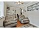 Comfortable living room with two recliners, ceiling fan, built-in shelves, and a view into the office nook and kitchen at 150 Whitney Way, Fayetteville, GA 30214