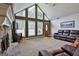 Open living room featuring vaulted ceilings, large windows, and a stone fireplace at 150 Whitney Way, Fayetteville, GA 30214