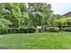 Expansive backyard with mature trees, a playset, and a well-maintained lawn at 1486 Maple Ridge Dr, Suwanee, GA 30024