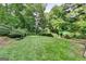 The expansive backyard features a lush green lawn, surrounded by mature trees, providing a serene and private outdoor space at 1486 Maple Ridge Dr, Suwanee, GA 30024