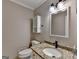 Clean half bathroom featuring modern fixtures and a granite countertop at 1486 Maple Ridge Dr, Suwanee, GA 30024