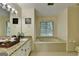 Bright bathroom with granite vanity, soaking tub, and neutral tile at 1486 Maple Ridge Dr, Suwanee, GA 30024