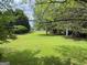 Expansive backyard with mature trees and storage buildings at 105 Carols Ln, Locust Grove, GA 30248