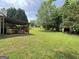 Lush backyard featuring a covered patio and well-maintained lawn, ideal for outdoor entertaining and relaxation at 105 Carols Ln, Locust Grove, GA 30248