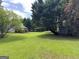 Large backyard with mature trees and a view of the home's back porch at 105 Carols Ln, Locust Grove, GA 30248