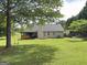 Backyard with patio, garden beds, mature trees, and a tree swing at 105 Carols Ln, Locust Grove, GA 30248