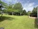 Expansive backyard with mature trees and a covered patio, perfect for enjoying outdoor living and recreation at 105 Carols Ln, Locust Grove, GA 30248