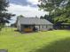 Large backyard with covered patio, garden beds, and mature trees at 105 Carols Ln, Locust Grove, GA 30248