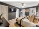 Cozy bedroom featuring dark walls, neutral bedding, ceiling fan and flatscreen television at 105 Carols Ln, Locust Grove, GA 30248
