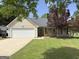 Charming single-story home with well-maintained lawn, two-car garage and mature landscaping at 105 Carols Ln, Locust Grove, GA 30248