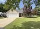 Charming single-story home with well-maintained lawn, two-car garage and mature landscaping at 105 Carols Ln, Locust Grove, GA 30248