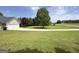 Well-manicured front yard with a spacious lawn and mature trees, creating a welcoming curb appeal at 105 Carols Ln, Locust Grove, GA 30248