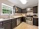 Well-lit kitchen features stainless steel appliances, dark cabinets and a view of the backyard at 105 Carols Ln, Locust Grove, GA 30248