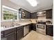 Bright kitchen showcasing stainless steel appliances, dark cabinets and a scenic view at 105 Carols Ln, Locust Grove, GA 30248