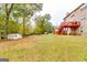 Spacious backyard featuring a shed, mature trees, and verdant grass at 1373 Fall River Dr, Conyers, GA 30013