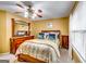 A bedroom with a ceiling fan features a bed with plush bedding, and natural light from a window at 1373 Fall River Dr, Conyers, GA 30013