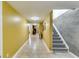 Long hallway with tile floor that features stairs, a yellow wall, and wall decor at 1373 Fall River Dr, Conyers, GA 30013