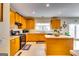 Well-lit kitchen with wooden cabinets, a black gas range, and a functional kitchen island at 1373 Fall River Dr, Conyers, GA 30013