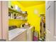 The yellow laundry room is equipped with a modern washer and dryer and ample storage shelving at 1373 Fall River Dr, Conyers, GA 30013