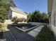 A modern home is complimented by a dark swimming pool, decorative trees, and stone patio at 10583 Serenbe Ln, Palmetto, GA 30268