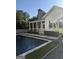 Backyard view of a swimming pool, patio, and modern home with stone chimney at 10583 Serenbe Ln, Palmetto, GA 30268
