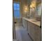 Bright bathroom featuring double vanity with marble countertop and charming white honeycomb tile flooring at 10583 Serenbe Ln, Palmetto, GA 30268