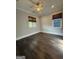 Bedroom featuring neutral walls, rich hardwood flooring, two windows with woven shades and a ceiling fan at 10583 Serenbe Ln, Palmetto, GA 30268