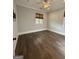 Bedroom featuring neutral walls, rich hardwood flooring, two windows with woven shades and a ceiling fan at 10583 Serenbe Ln, Palmetto, GA 30268