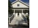 View of the large front porch and gray front door of this charming two-story home at 10583 Serenbe Ln, Palmetto, GA 30268