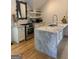 Modern kitchen featuring stainless steel appliances, a marble island and light hardwood flooring at 10583 Serenbe Ln, Palmetto, GA 30268