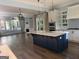 Open-concept kitchen featuring a large blue island, stainless steel appliances, and hardwood floors at 10583 Serenbe Ln, Palmetto, GA 30268