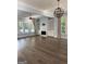 Bright living room with hardwood floors, a fireplace, built-in shelves, and large windows with outdoor views at 10583 Serenbe Ln, Palmetto, GA 30268