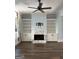 Cozy living room with built-in bookshelves, hardwood floors, and a fireplace featuring marble surround at 10583 Serenbe Ln, Palmetto, GA 30268