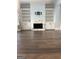 Spacious living room with hardwood flooring, built-in bookshelves and a marble fireplace surround at 10583 Serenbe Ln, Palmetto, GA 30268