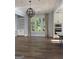 Open-concept living room with hardwood floors, a fireplace, built-in bookshelves, and large windows at 10583 Serenbe Ln, Palmetto, GA 30268
