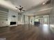 Spacious living room featuring a fireplace, hardwood floors, and an open floor plan leading to the kitchen at 10583 Serenbe Ln, Palmetto, GA 30268