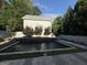 Backyard pool and hardscape surrounded by a well-maintained lawn and mature trees at 10583 Serenbe Ln, Palmetto, GA 30268