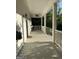 View of the porch with white columns, gray deck, and ceiling fan at 10583 Serenbe Ln, Palmetto, GA 30268