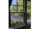 Bright window view overlooking a tranquil street lined with lush greenery and a wooden fence at 10583 Serenbe Ln, Palmetto, GA 30268