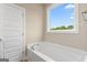 Bright bathroom featuring a soaking tub and a large window offering great natural light at 123 Oak Road, Locust Grove, GA 30248